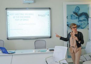 Marilena Di Coste in front of presentation screen